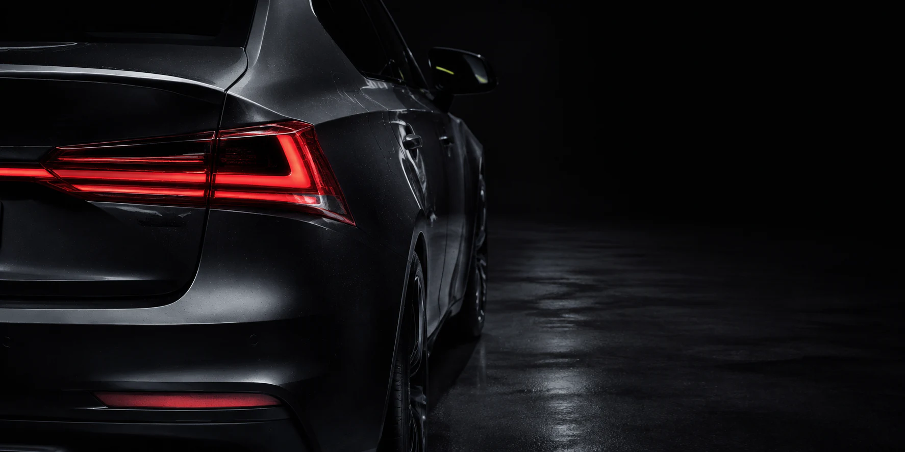 Rear detail of a modern car in a dark studio